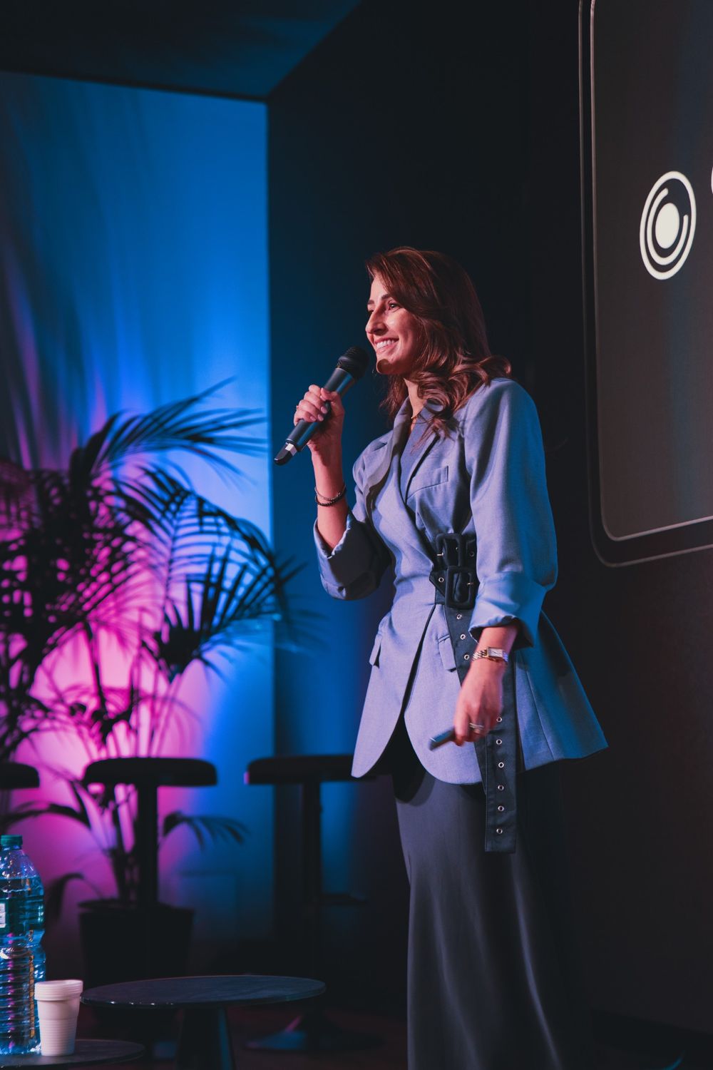 Camilla Brossa sorride al pubblico con il microfono in mano, sul palco di Torino Tech Map alla Feat House
